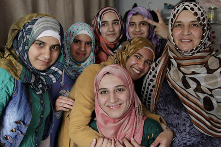 7 refugee women looking at the camera and smiling