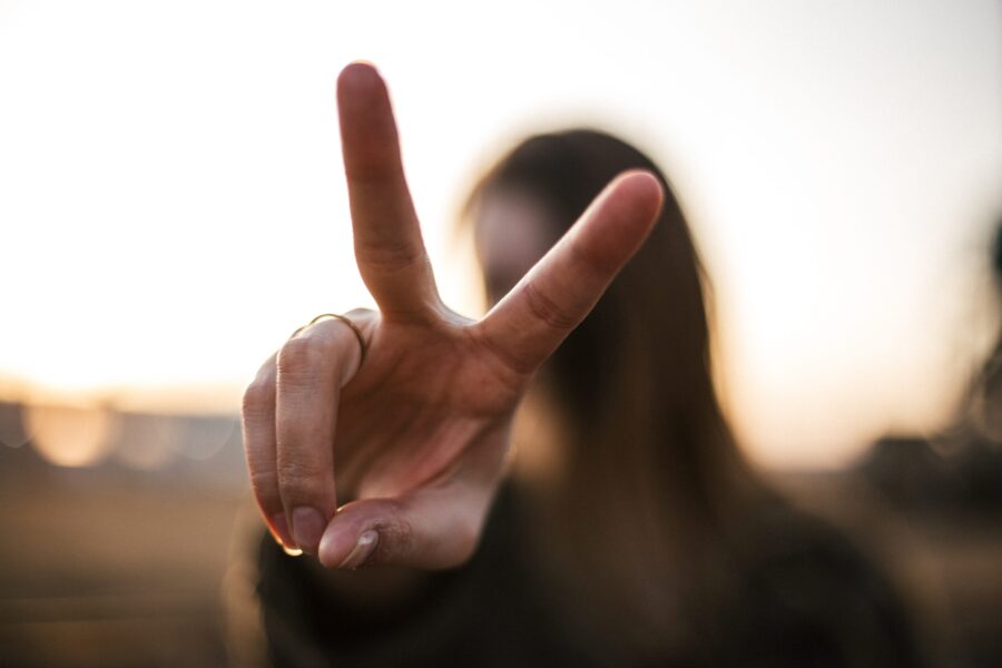 a woman forms the symbol of victory with her fingers