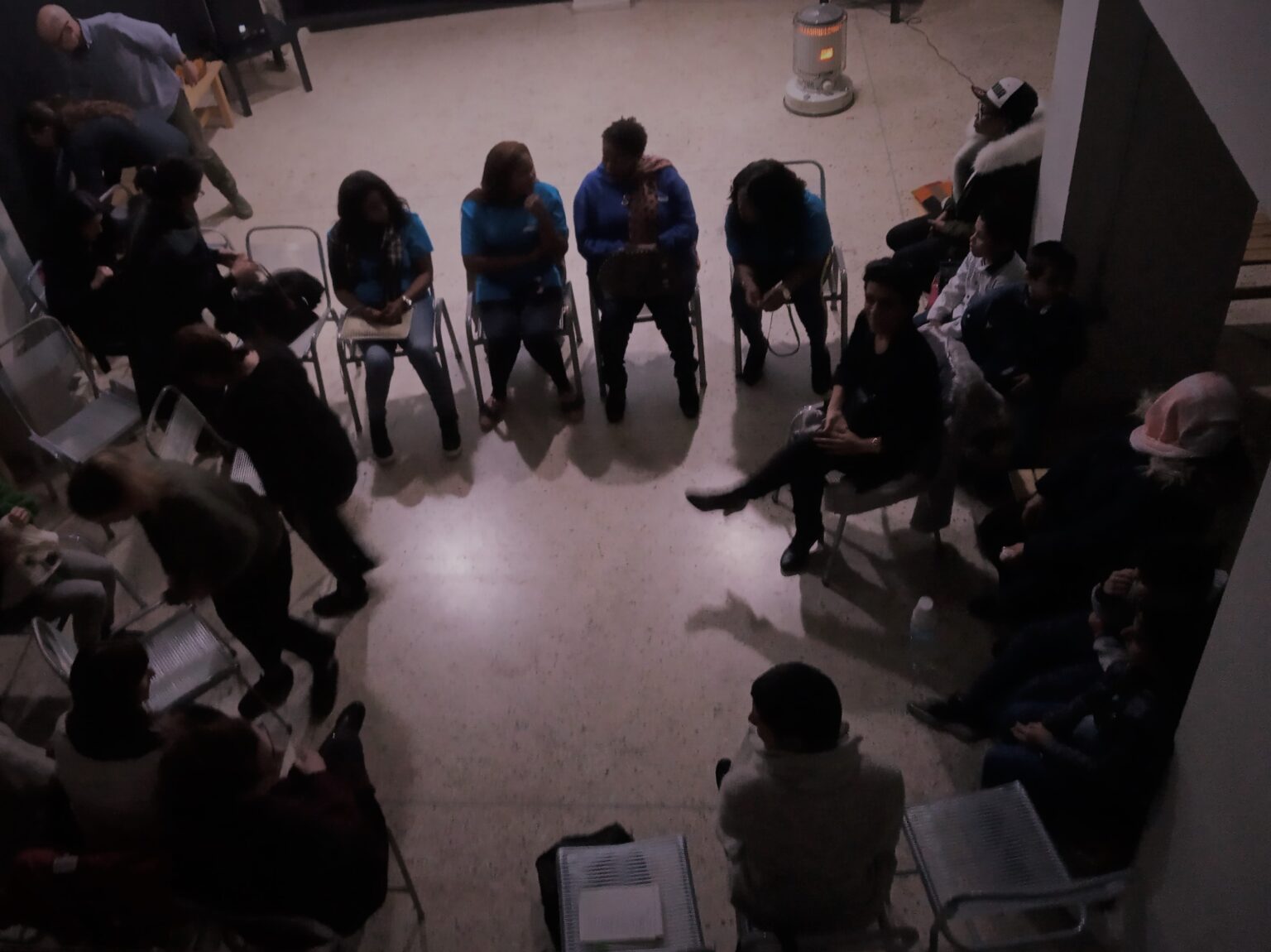 Άτομα καθισμένα σε καρέκλες σε κύκλο, το εσωτερικό μιας αίθουσας