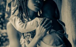 Αφρικάνα κρατά ένα μωρό στην αγκαλιά της