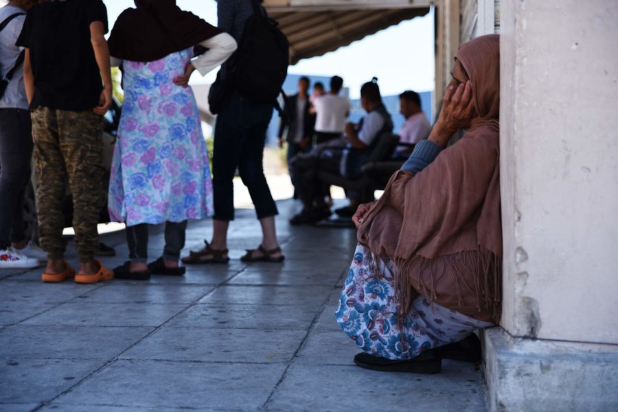 πρόσφυγες/ισσες σε υπαίθριο χώρο, άλλοι/ες συνομιλούν όρθιοι/ες κι άλλοι/ες κάθονται σιωπηλοί/ες