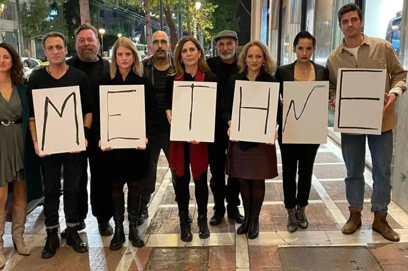 Φωτογραφία. Άτομα με πλακάτ στα χέρια, με γράμματα που σχηματίζουν τη φράση "με την Ε"