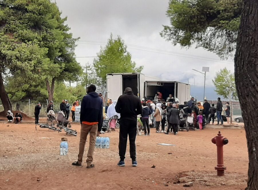 refugees in line outside a ration distribution container