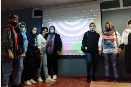 attendants and workers of the Thessaloniki group around a surface displaying a presentation