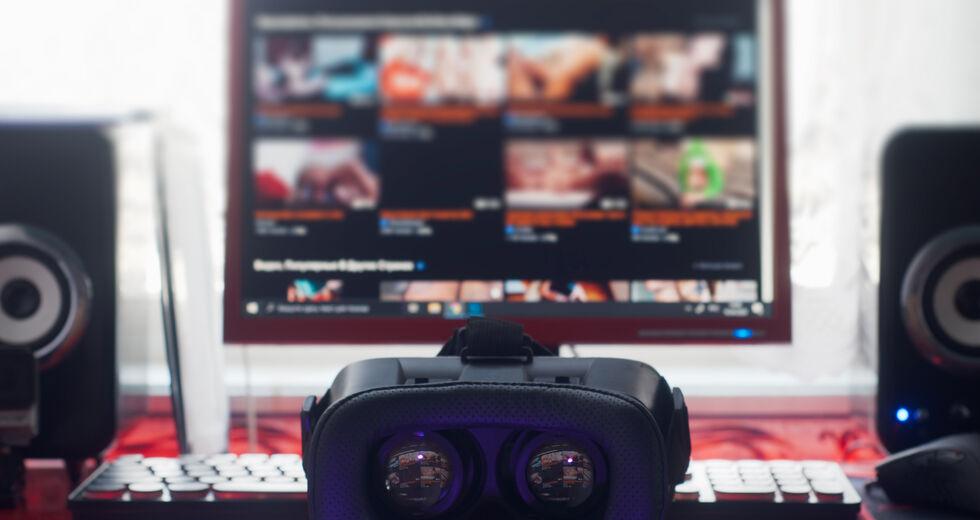 στο φόντο μια οθόνη υπολογιστή με πολλά παράθυρα, στο κέντρο της φωτογραφίας είναι ένα ζευγάρι κιάλια