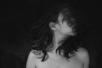 black and white photo, a woman with closed eyes turns her head to the right