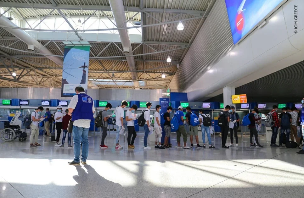 young refugee women in line for boarding passes at Athens airport