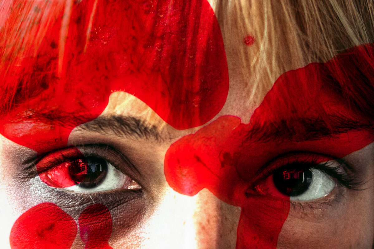 τα μάτια μιας γυναίκας πίσω από ένα κόκκινο φίλτρο