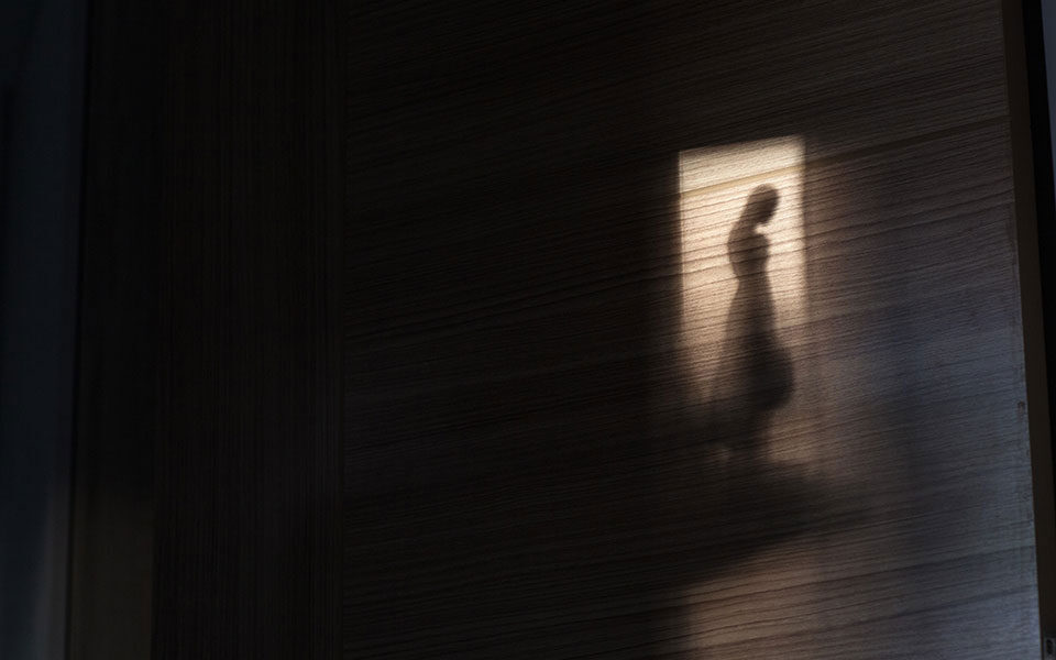 μια γυναικεία φιγούρα διακρίνεται στο άνοιγμα μιας πόρτας