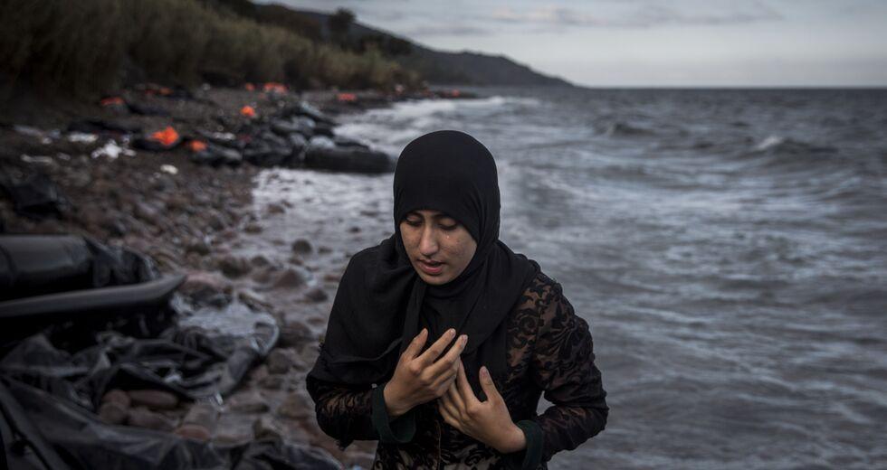 προσφύγισσα απομακρύνεται από ένα ναυάγιο με τα χέρια σταυρομένα στο στήθος