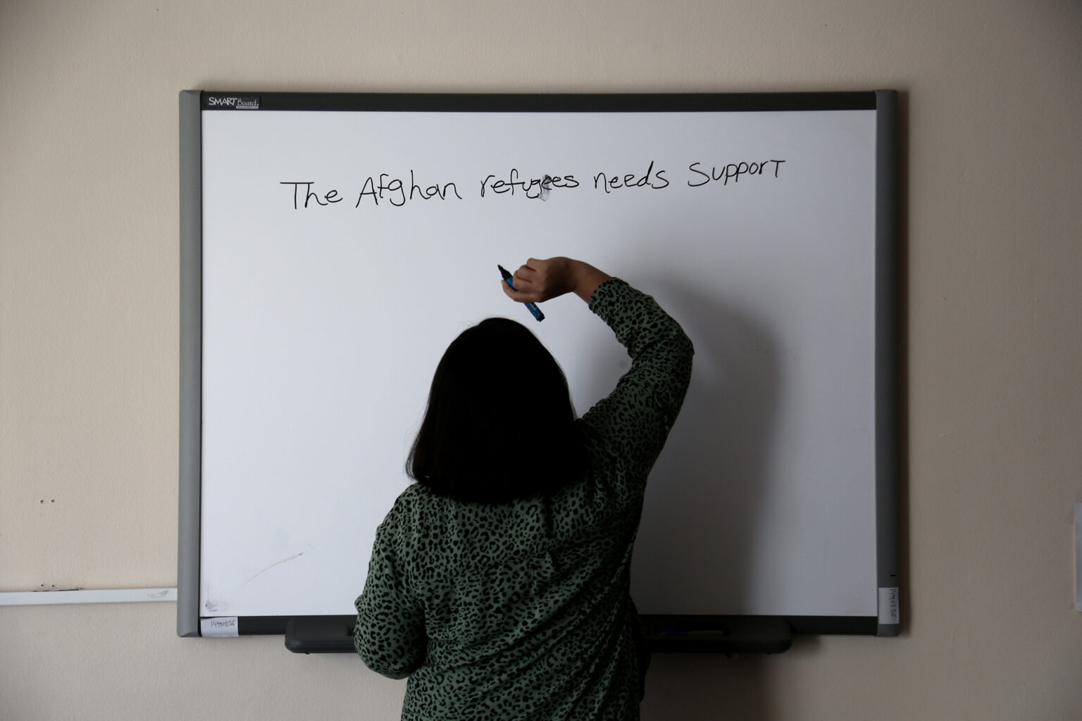 «Οι Αφγανές προσφύγισσες χρειάζονται υποστήριξη» γράφει μία γυναίκα στον πίνακα