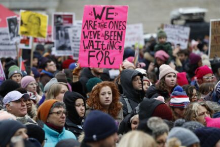 snapshot of a feminist protest in Manhattan, New York, a pink placard reads "We are the ones we've been waiting for"