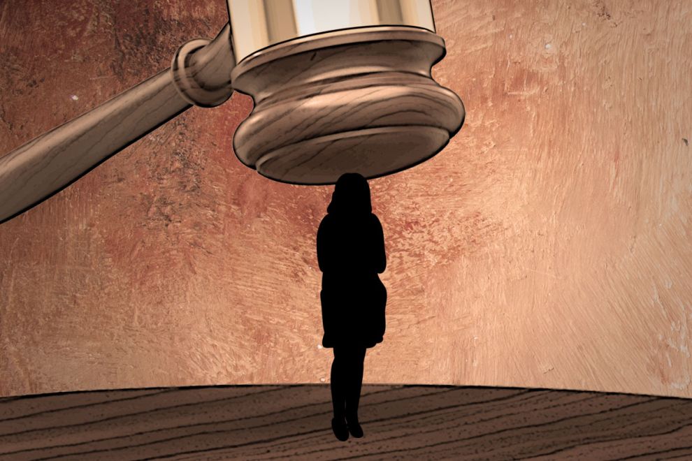 γραφιστικό που απεικονίζει μια γυναικεία φιγούρα και από πάνω της ακριβώς ένα σφυρί του δικαστή μεγαλύτερο από το ανθρώπινο μέγεθος