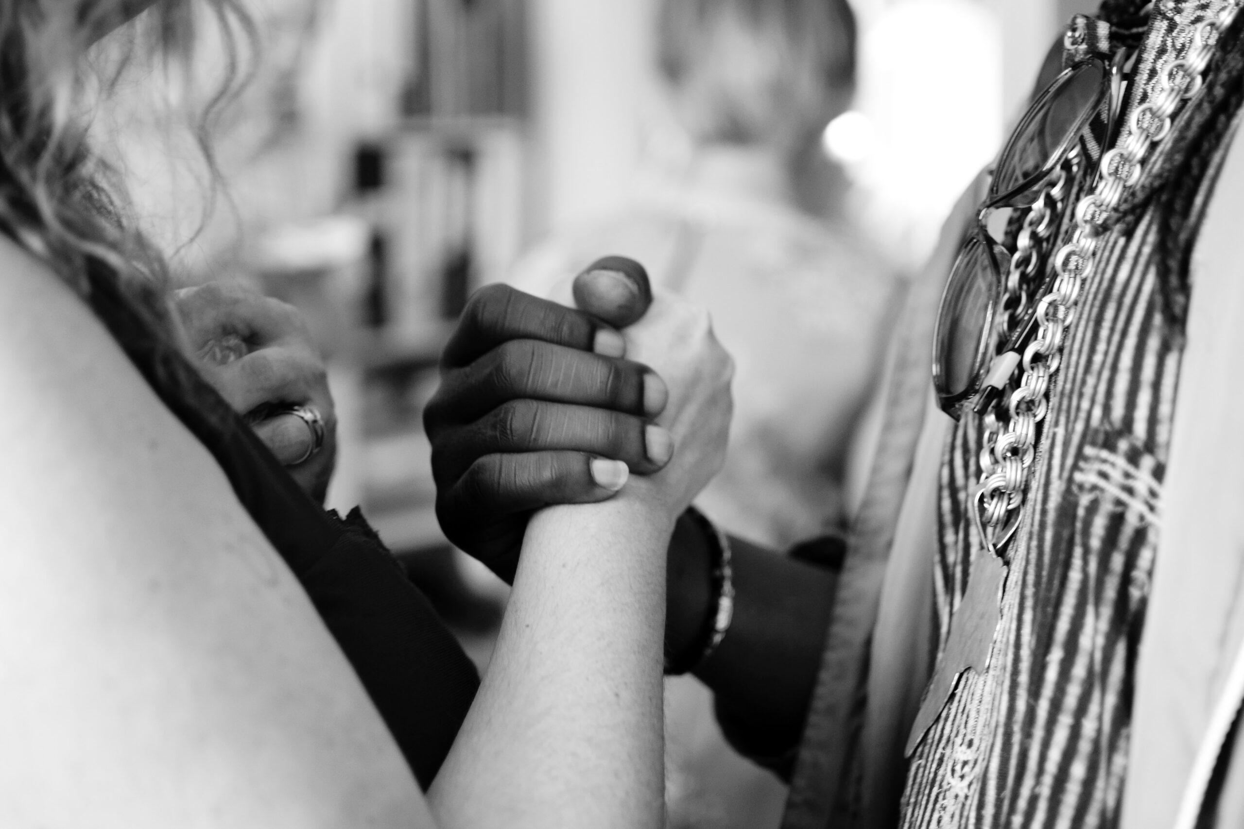 two women shaking hands, one white and one African