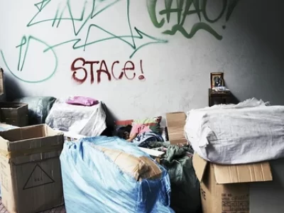 κούτες, σκεπάσματα και κάποια προσωπικά αντικείμενα πάνω σε ένα πεζοδρόμιο