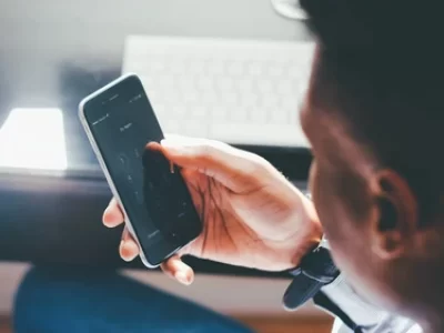 ένας άνδρας πληκτρολογεί έναν αριθμό στο κινητό του