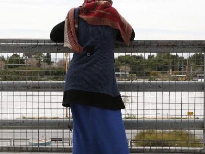 προσφύγισσα ατενίζει από ψηλά έναν υπαίθριο χώρο