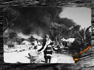 ασπρόμαυρη φωτογραφία, μια γυναίκα με μαντίλα τρέχει με πράγματα στα χέρια, πίσω της διακρίνονται μεγάλοι μαύροι καπνοί