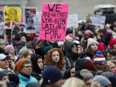 snapshot of a feminist protest in Manhattan, New York, a pink placard reads "We are the ones we've been waiting for"